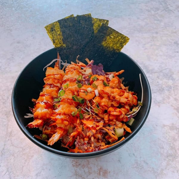 Wabi Sabi's Japanese shrimp poke bowl with nori, vegetables, and sauce in a black bowl.
